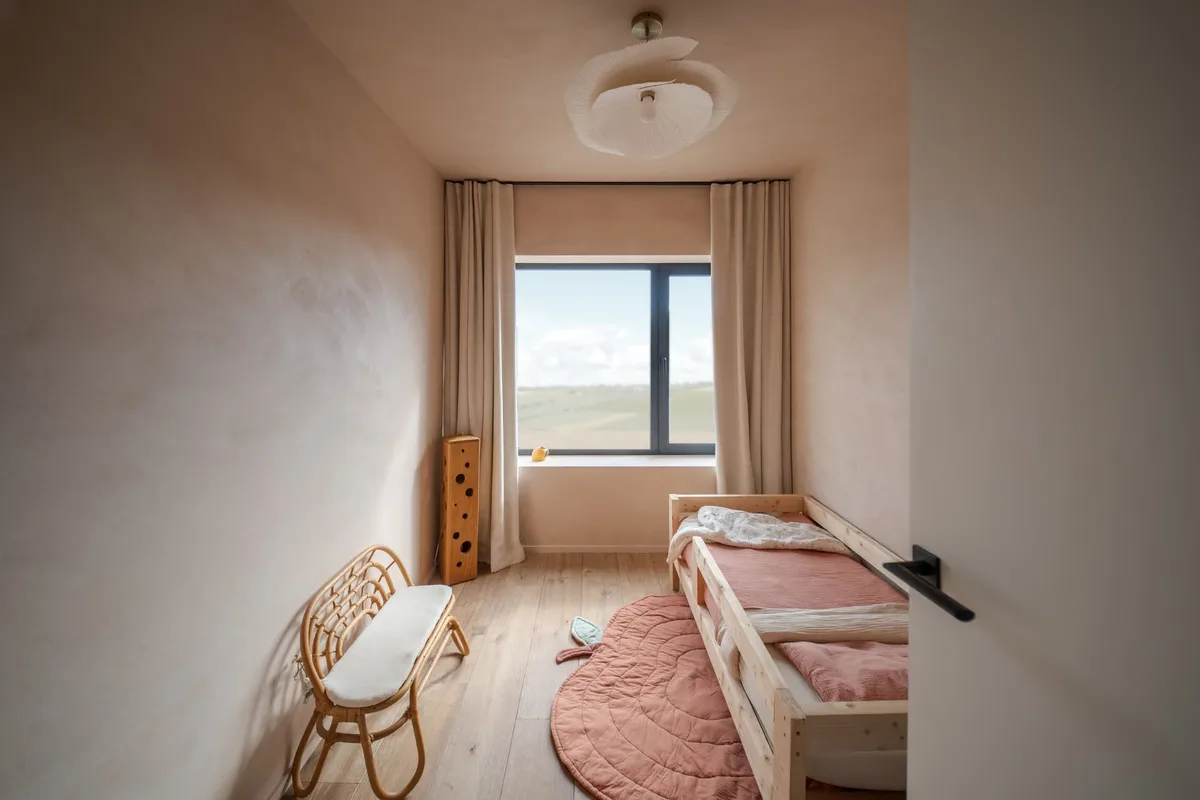 Chambre en enduit à la chaux teinte Peach, parquet chêne et rideaux en lin à Neufchâteau