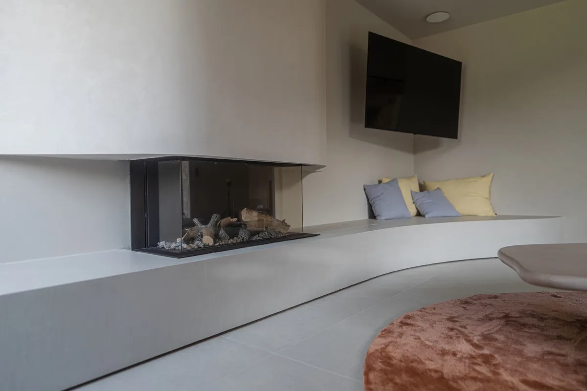 Séjour avec cheminée et banquette en béton ciré gris